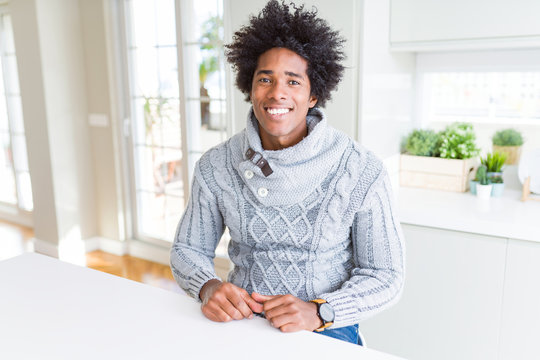 African American man wearing winter sweater with a happy and cool smile on face. Lucky person.