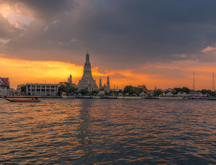 Fototapeta na wymiar Twilight wallpaper in the evening,the sun going back to the horizon,Wat Arun Ratchawaramaram is a temple along the ChaoPhraya River is an important place and a beautiful tourist destination in Bangkok