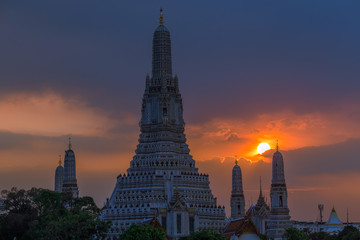Obraz premium Twilight wallpaper in the evening,the sun going back to the horizon,Wat Arun Ratchawaramaram is a temple along the ChaoPhraya River is an important place and a beautiful tourist destination in Bangkok