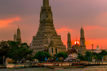 Fototapeta premium Twilight wallpaper in the evening,the sun going back to the horizon,Wat Arun Ratchawaramaram is a temple along the ChaoPhraya River is an important place and a beautiful tourist destination in Bangkok