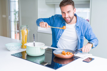 Handsome man cooking pasta at home