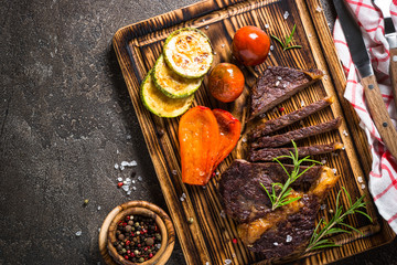 Grilled beef steak with vegetables top view.