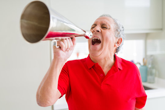 Senior man shouthing excited through vintage metal megaphone