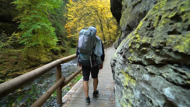 POV of father traveling in the wild nature with son in touristic backpack, Czech Switzerland