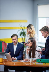 Team of mature women and men at meeting table discussing a business plan