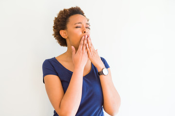 Young beautiful african american woman over white background bored yawning tired covering mouth with hand. Restless and sleepiness.