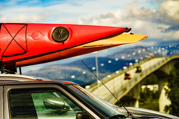 Car with canoes on top roof in mountains