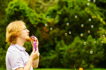 Man blowing soap bubbles outdoor