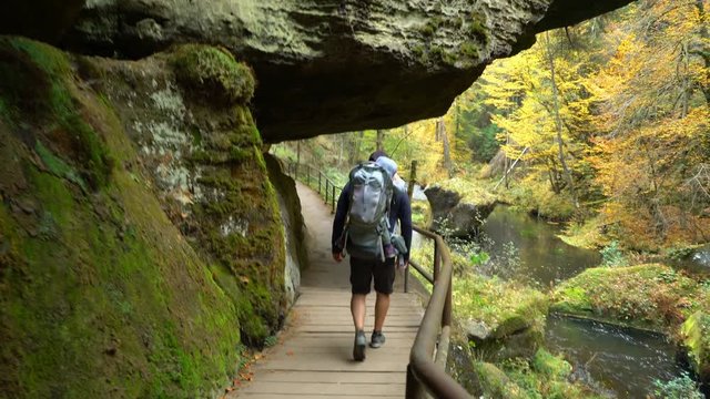 POV of father traveling in the wild nature with son in touristic backpack, Czech Switzerland