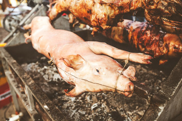pork rotating on the spit over hot charcoal