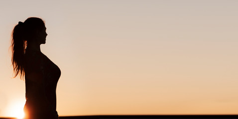 Silhouette einer Frau mit Pferdeschwanz Frisur im Gegenlicht © by-studio