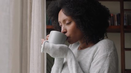 beautiful african american woman looking out window drinking coffee enjoying fresh new day feeling rested