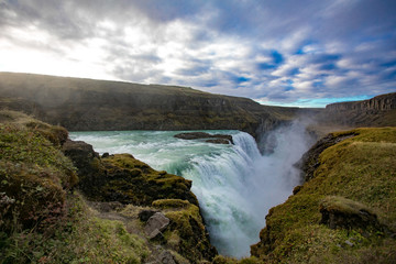 View of a waterfall in Iceland. Water flows from top to bottom.