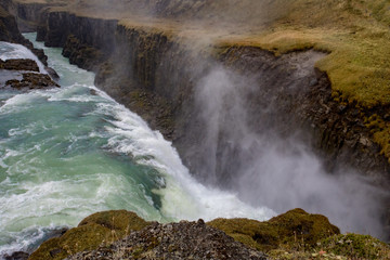 View of a waterfall in Iceland. Water flows from top to bottom.