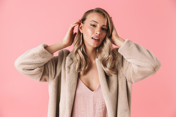 Amazing young pretty woman posing isolated over pink wall background.