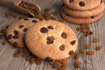 Oatmeal cookies with raisins,  on a dark wooden background with a wooden spoon