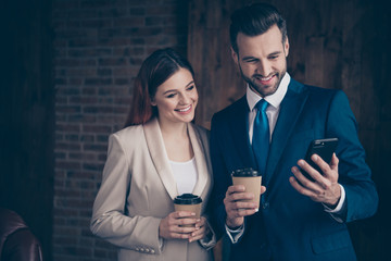 Close up photo she her business lady he him his guy buddies hold hot beverage hands arms look smart phone pictures leisure rejoice morning tea coffee stand office wearing formal wear suits