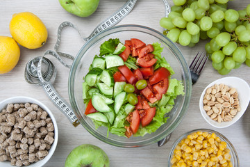 notebook with a diet plan with fresh vegetables and fruits and a side dish
