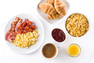 Breakfast with scrambled eggs, bacon, tomatoes,coffee,orange juice ,croissant and corn flakes isolated on white background. Top view