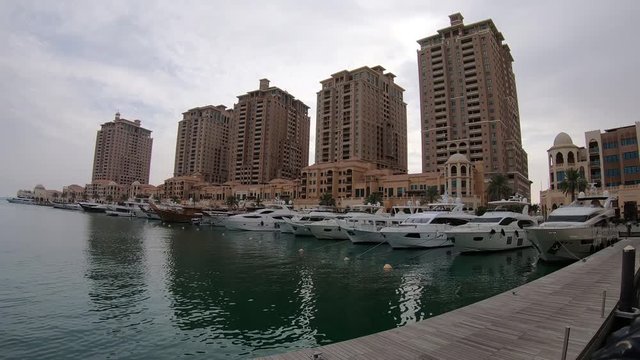Doha, Qatar - February 2019: Yachts and boats in the marina area inside residential area of The Pearl, close to Doha, an artificial island spanning nearly four million square meters.