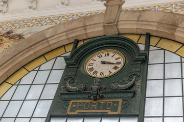 Fototapeta na wymiar Clock of the historical Sao Bento train station in Porto, Portugal