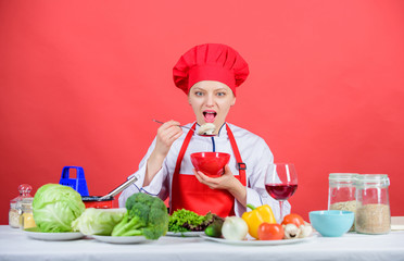 Dieting concept. Eat healthy. Girl wear hat and apron try meal taste. Healthy ration. Woman professional chef hold bowl and spoon. Free healthy vegetarian and vegan recipes. Healthy raw food
