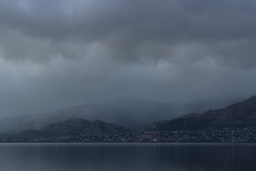 Naklejka premium Beautiful reflections of clouds and mountains in the water of a lake