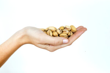 Young woman hand holding pistachios on isolated white background.