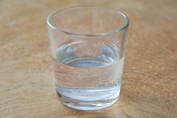 A glass of water on a wooden background