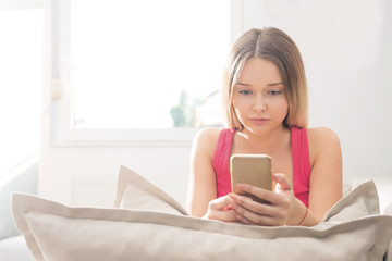 Young woman using smartphone on sofa