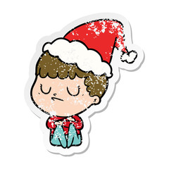 distressed sticker cartoon of a grumpy boy wearing santa hat