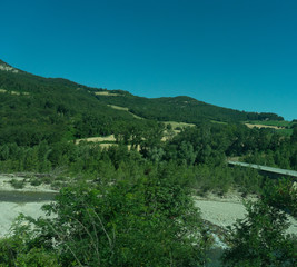 Fototapeta na wymiar Italy,La Spezia to Kasltelruth train, a bridge over a body of water with a mountain in the background