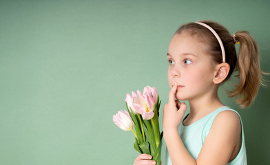 Adorable smiling little girl with tulips