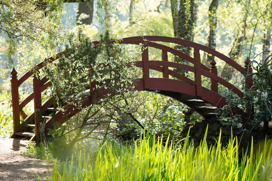 Fr&uuml;hling im Paradies - Romantische rote Br&uuml;cke im Gr&uuml;nen