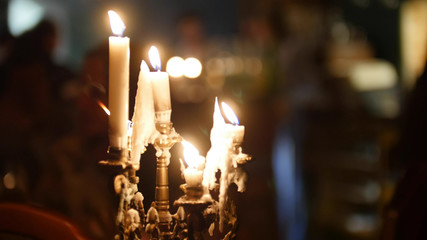 White candles flaming at the restaurant. Mystical atmosphere