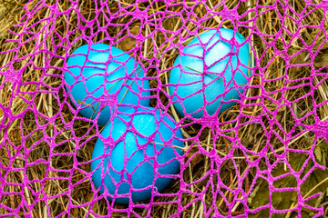 Easter eggs concept abstract art decoration. On dry herbs background with pink cloth grid.