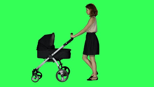 A mother walking with a stroller, looking around and at her baby, smiling, over a green screen.