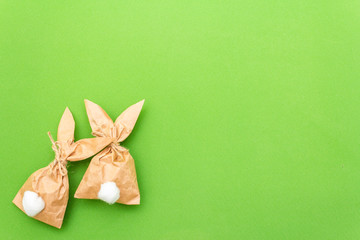 Easter bunny paper gift egg wrapping DIY idea on colorful background. Minimal easter concept, flat lay, copy space.