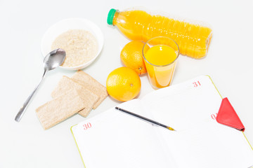 Healty breakfast with muesli, and orange juice. View from above on wooden table with notepad for copy space.