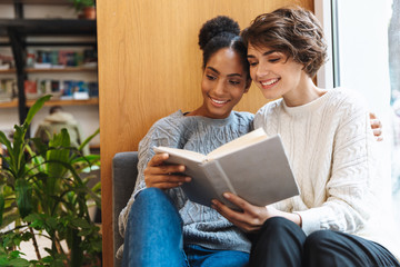 Two cheerful young girls students studying