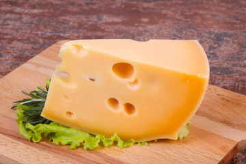 Maasdam cheese  in the board served salad leaves