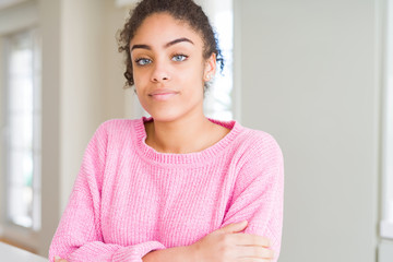 Beautiful young african american woman with afro hair Relaxed with serious expression on face. Simple and natural with crossed arms