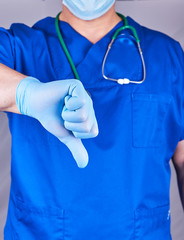 doctor in blue uniform and latex sterile gloves shows a gesture is bad