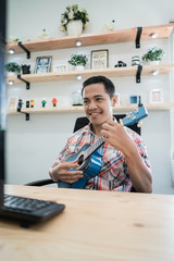 happy worker playing with his guitar while looking at his computer in the office