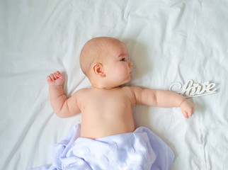 baby lies in a white bed