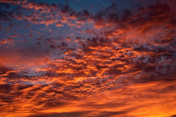 A majestic and awe-inspiration combination of deep blue sky and fiery orange and yellow clouds at sunset.