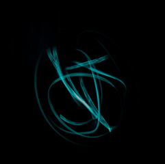 Freeze light photo, made with light painting or light drawing, abstract streaks turquoise color on black background