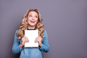 Portrait of her she nice cute lovely sweet fascinating charming attractive cheerful wavy-haired lady wearing blue shirt holding in hands tablet fantasize fancy isolated over gray pastel background