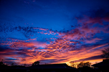 A majestic and awe-inspiration combination of deep blue sky and fiery orange and yellow clouds at sunset.