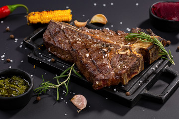 T-bone beef stake served on a cutting board, view from above